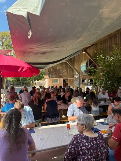 Volle Festbänke unter dem Sonnensegel im Hof